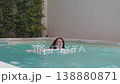 Young woman swimming in outdoor pool enjoying 138880871