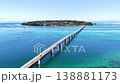 Aerial footage showing the Kouri Bridge and Kouri Island in Okinawa, with the emerald green sea stretching out before you. 138881173