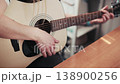Woman's hands strumming an acoustic guitar 138900256