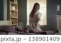Young woman waking up in her bedroom feeling pain in her lower back, suffering from sciatica or muscle strain after a bad night's sleep on an uncomfortable mattress 138901409