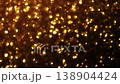 Densely packed amber and golden bokeh particles creating a high-density shimmering effect with brilliant light flares on black. 138904424
