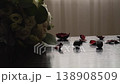 White roses and eucalyptus leaves form a delicate bouquet, while red rose petals are artfully strewn across a polished wooden surface. The scene is softly illuminated by diffused daylight 138908509