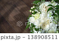A close up of a sophisticated white rose bouquet with lush green leaves and delicate accents, resting on a polished wood floor. Ideal for floral design, celebration, or nature inspired visuals 138908511