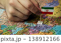 Person places Iranian flag on map highlighting country in Middle East. 138912166