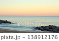 Wide beach with calm sea and rocky breakwaters at sunset 138912176