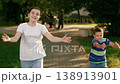 Family, children, parents walking in park. Children run to dad mom hugs in park. Family walk in outdoors, hugging mom dad, kids son daughter. Weekend in nature park in summer. Concept raising children 138913901