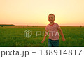 Kid laughs runs across green grass, sunset. Small child plays on lawn. Child active games. Happy boy laughs while play on lawn. Small boy runs green grass with arms raised. Family picnic, kid nature 138914817