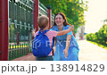 Child runs to mother hugs her in park outside in summer. Happy family. Carefree childhood, baby joyfully runs to mom. Small child son happily plays outside with his parent in summer. Mommy son, street 138914829