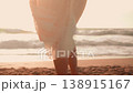 Woman with wine glass walking on beach near ocean 138915167