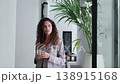 Young woman in pajamas drinking coffee in hallway 138915168