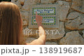 Tourist pointing at Piazza Umberto I sign on stone wall in Capri Italy on a sunny summer day 138919687