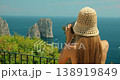 A woman observes the iconic Faraglioni sea stacks on Capri Italy during a sunny summer trip 138919849