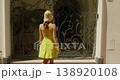 A woman walks toward an ornate gate on a busy summer street Via Camerelle on sunny summer day in Capri Italy 138920108
