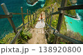 Woman in white dress walks down steep path at Kelingking Beach in Nusa Penida 138920800