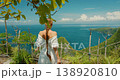 Woman traveler walking at scenic viewpoint and overlooking the iconic T Rex cliff and ocean in Bali Nusa Penida Indonesia 138920810