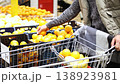 Close-up of a hands of a man selects fresh oranges from the supermarket counter. He carefully examines each piece before making his choices. 4k footage. 138923981