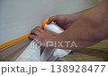Man applying protective tape along baseboard 138928477