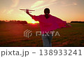Teenage girl playing with toy airplane on green lawn. Happy girl play with toy airplane on autumn meadow sun, slow motion. Cheerful girl dreams of fly airplane, travel. Child holds plane in hand 138933241