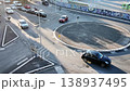 Busy urban roundabout bustling with cars during the late afternoon in a vibrant city setting filled with street art 138937495