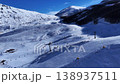 Skiers carve down snow-covered slopes beneath a brilliant blue sky in a picturesque mountain resort 138937511
