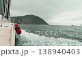 A motorboat fast sails across the sea during cloudy, choppy weather, as seen from the side. Waves splash in all directions 138940403