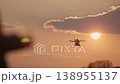 Silhouette of a drone operator's hand with a remote control, controlling 138955137