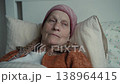 Portrait of seriously ill elderly woman lying in bed looking out window 138964415