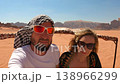 Close-up POV of a young man and a young woman riding in a vehicle across the red sand dunes of Wadi 138966299
