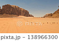 Aerial view of red sand dunes and sandstone rock formations with a distant desert camp, Wadi Rum 138966300