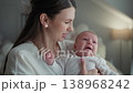 Mother comforts crying baby holding infant gently. Woman parent child family love joy parenthood cozy home adorable moment childhood innocence peaceful calm nurturing affection warmth. 138968242