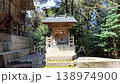 A quiet scene of a small shrine standing beside a Shinto shrine. 138974900
