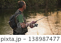 Slow motion of fisherman standing in river casting fishing line with spinning rod. Outdoor activity 138987477