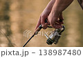 Close up of fisherman hands reeling fishing line with spinning rod. Outdoor leisure activity 138987480