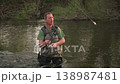 Slow motion of fisherman standing in river casting fishing line with spinning rod. Outdoor activity 138987481