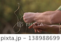 Slow motion close up of fisherman unrolling fishing line before casting. Outdoor angling preparation 138988699
