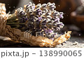 Dried lavender flower bundle wrapped in craft paper resting on weathered wooden surface 138990065