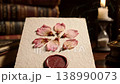 Handcrafted textured paper with arranged dried pink petals and decorative wax seal 138990073