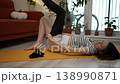 Pregnant woman lying on a yellow yoga mat putting on compression stockings to prevent varicose veins and improve circulation, reducing swelling and leg discomfort during pregnancy 138990871