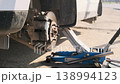 Car with Removed Wheel on Jack During Tire Replacement 138994123