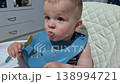 Adorable messy baby eating oatmeal in high chair 138994721