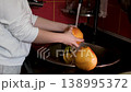 Rinsing fresh grapefruits in pink terracotta kitchen sink woman hands washing citrus fruit preparing healthy home snack close-up 138995372