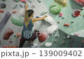 slow motion footage of female rock climber practicing on climbing wall, slow motion shot of woman climbing, extreme sports, bouldering practice . High quality 4k footage 139009402
