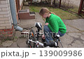 Teenage girl pumping air into a bicycle tire 139009986
