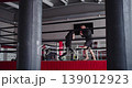 A young Caucasian woman practices boxing with a trainer. She practices slips, rolls, and defending herself from a coach's punches. Slow motion 4k footage. 139012923