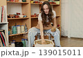 Young woman shaping clay on pottery wheel in ceramic workshop, handmade pottery process and creative craft activity in studio 139015011