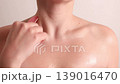 Woman holding facial roller and cosmetic serum dropper during skincare routine, beauty treatment and facial care concept 139016470