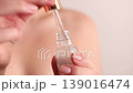 Woman using glass dropper to apply facial serum from cosmetic bottle, skincare routine and beauty treatment concept 139016474