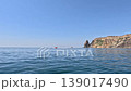 Water sports, jet ski, tube riding, people enjoy summer vacation fun on calm blue sea near rocky coastline. 139017490