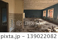 Sunlit Abandoned School Hall With Rubble And Dust, Broken Benches And Scattered Timber, Peeling Plaster On Tiled Lower Walls, Cracked Concrete Floor, Warm Window Light Casting Long Shadows, 139022082