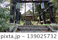 A tranquil scene of a shrine with a black torii gate and its approach. 139025732